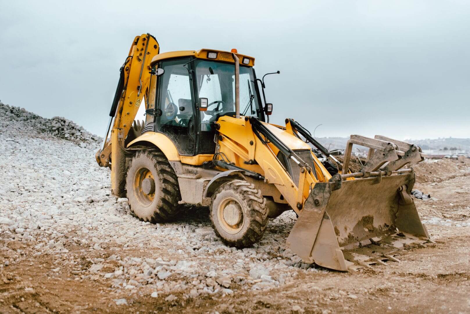 Yellow backhoe on construction site.