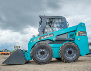 Blue construction vehicle on gravel ground.
