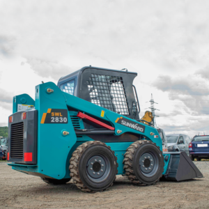 Blue and black skid steer loader parked.