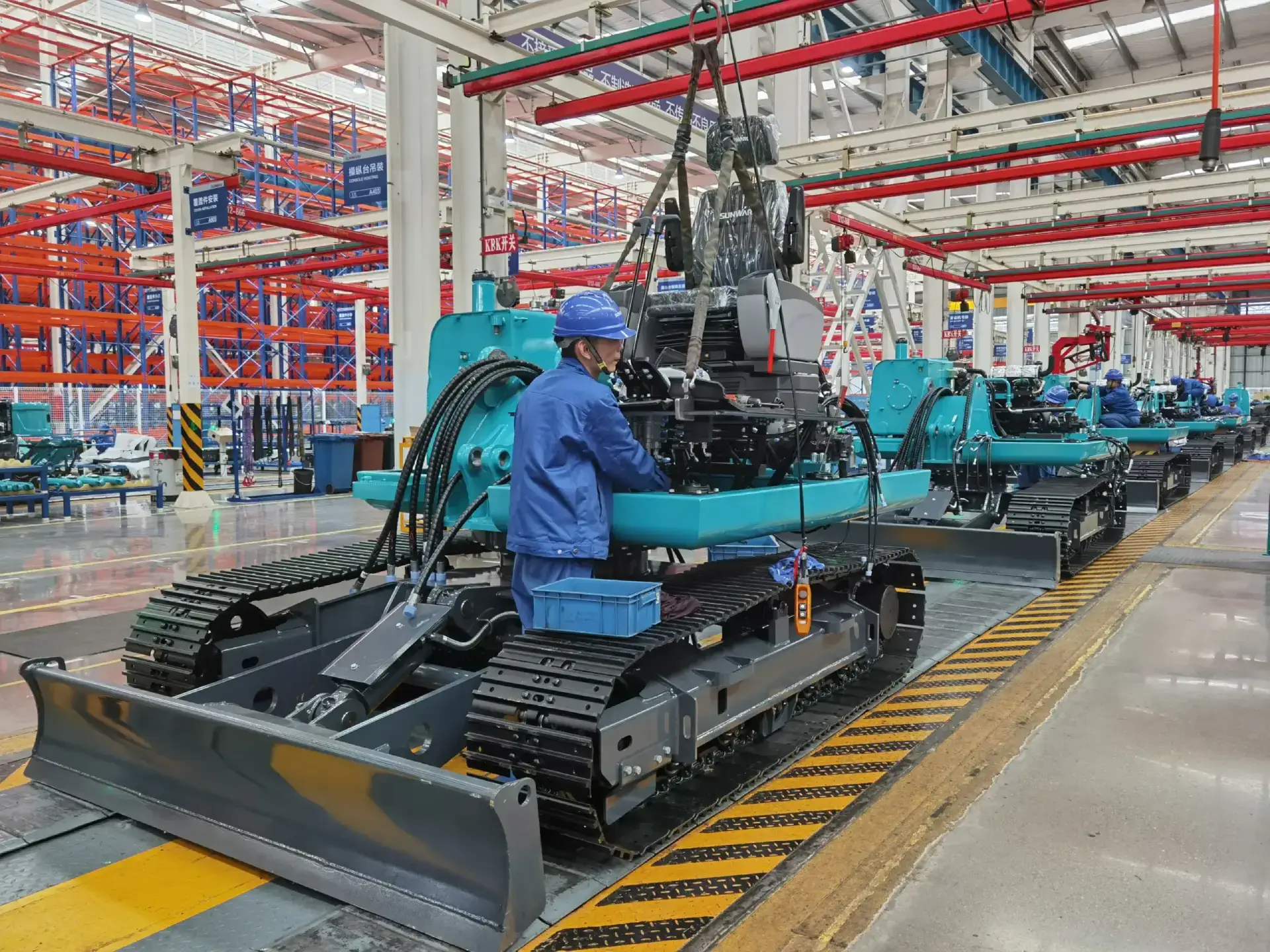 Worker assembling machinery in a factory setting.