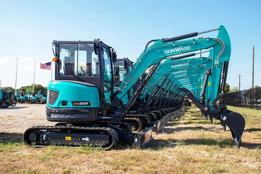 A blue and black tractor is parked in the grass