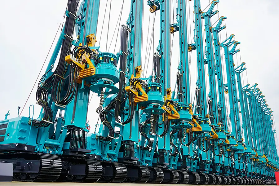 A bunch of blue and yellow cranes are lined up